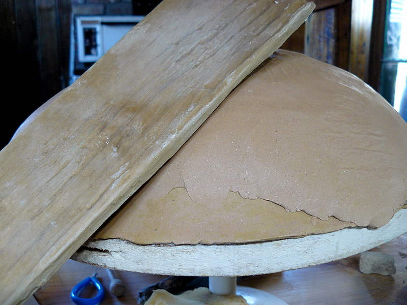 I rolled out another sheet of clay and put it on to thicken up the bowl. then I bashed it with a piece of driftwood.